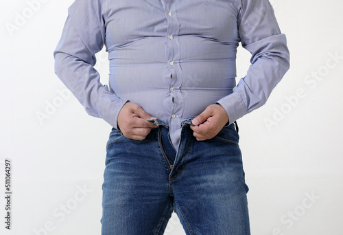 A fat man is struggling to wear tight pants and a shirt photo