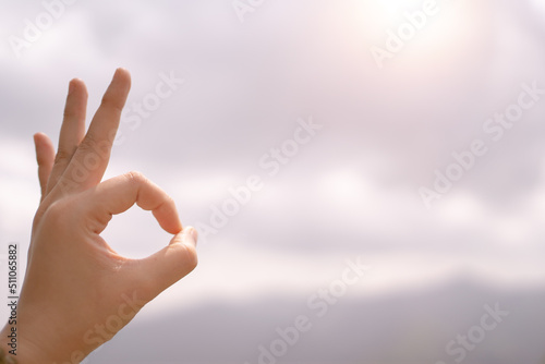 Woman hand with OK sign on green blur background