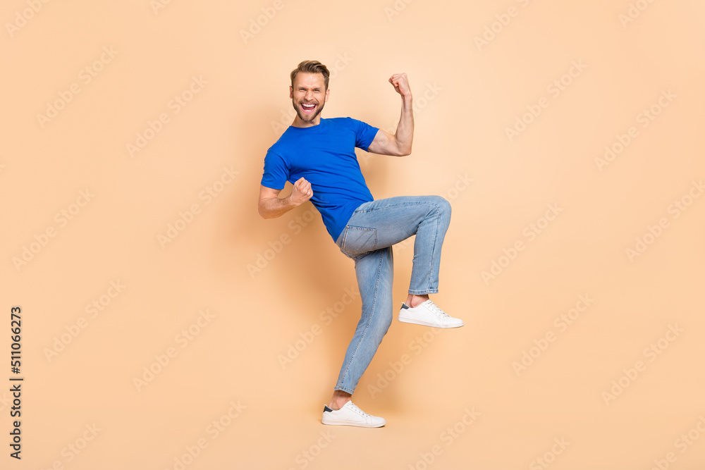 Full size portrait of positive delighted person raise fists scream yes isolated on beige color background