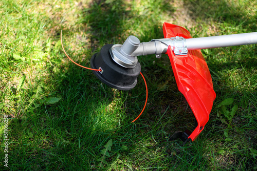 Vászonkép Reel of gas trimmer with fishing line, lawn mower on grass background