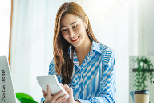 Young Asian businesswoman using calculator to calculate work graph business data and analysis.