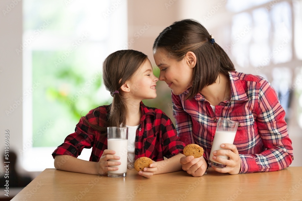 Happy Family Mother And Daughter Holding Glasses While Sitting Together In Kitchen, Enjoying Healthy Drink Happy Family Mother And Daughter Holding Glasses While Sitting Together In Kitchen, Enjoying Healthy Drink