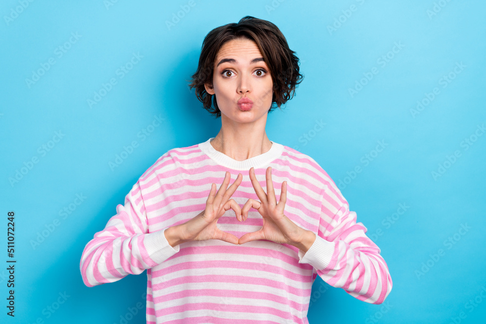 Photo of cute good mood stunning young woman kiss you show heart like symbol isolated on blue color background Photo of cute good mood stunning young woman kiss you show heart like symbol isolated on blue color background