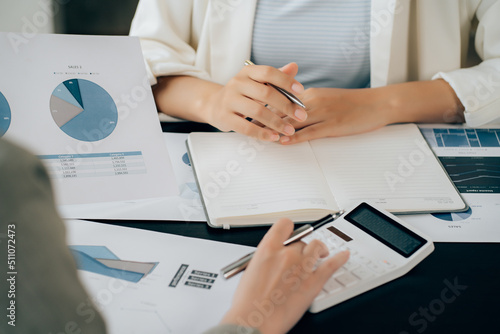 Business women using calculator at working with financial report.