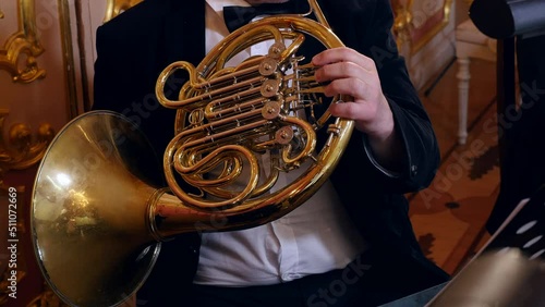 Musician playing french horn in symphony orchestra photo