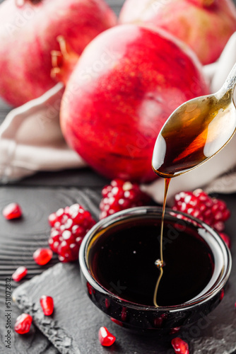 fresh pomegranate sauce narsharab on a black wooden rustic background photo