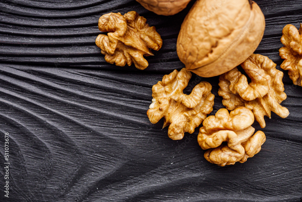 dried walnuts on a black rustic wooden background dried walnuts on a black rustic wooden background