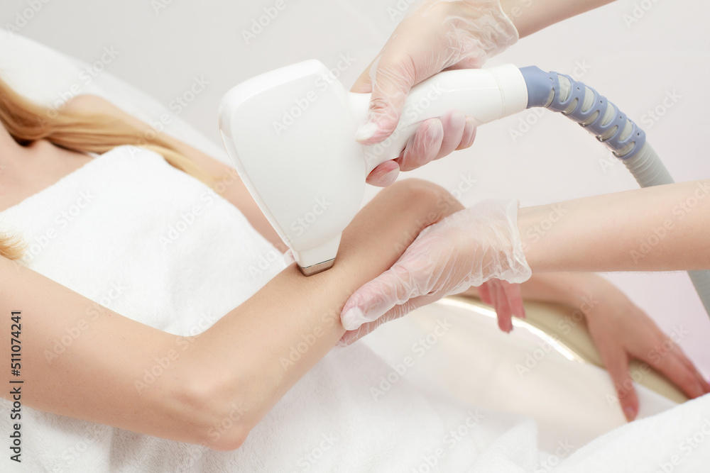 Diode laser hair removal, Beautician removes hair on female arm, Hair