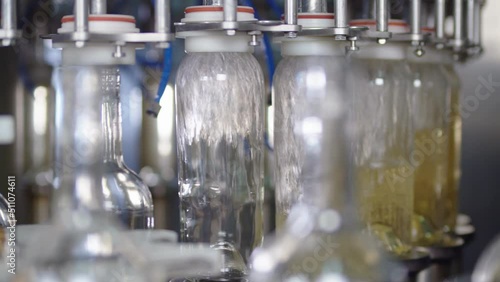 Wine production factory. Glass bottles filled up with white wine Bottling production line.
