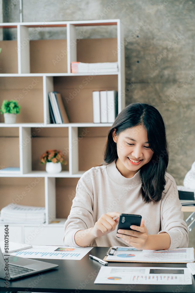 Asian businesswoman in formal suit in office happy and cheerful during using smartphone and working Asian businesswoman in formal suit in office happy and cheerful during using smartphone and working