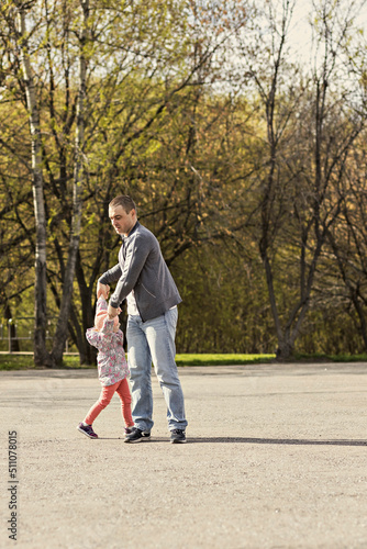 Dad is playing with his daughter in the backyard. Unwinds it around itself. Family, dad plays with his daughter on weekends