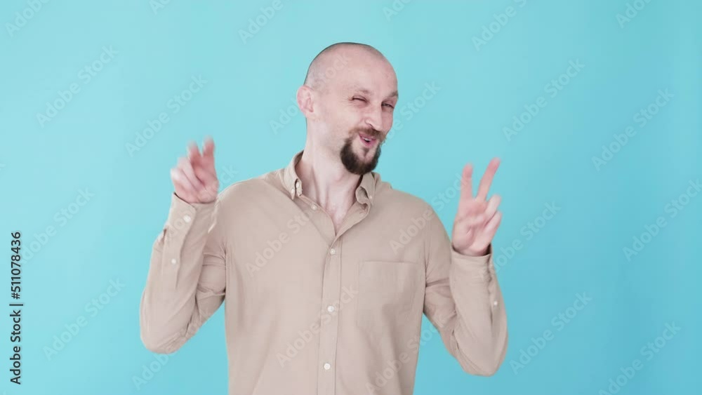Peace gesture. Victory celebration. Boomerang animation. Positive emotion. Optimistic happy funny man grimacing showing V sign gif loop isolated on blue free space background. Peace gesture. Victory celebration. Boomerang animation. Positive emotion. Optimistic happy funny man grimacing showing V sign gif loop isolated on blue free space background.