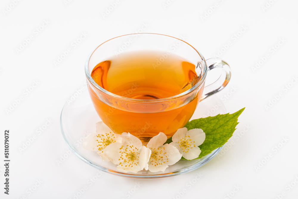 Composition with cup of jasmine tea and flowers on light background