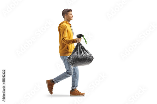 Full length profile shot of a casual guy carrying a plastic waste bag © Ljupco Smokovski
