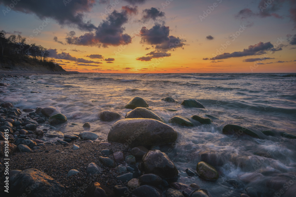 Naklejka premium Colorful sunset on the sea rocky shore
