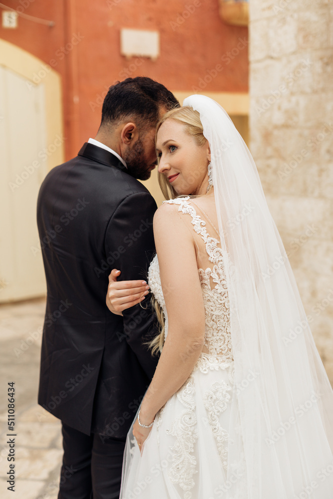 Fototapeta premium Vertical portrait of romantic married couple, after wedding, overdressed, stand outside. Italy vacation, travel abroad