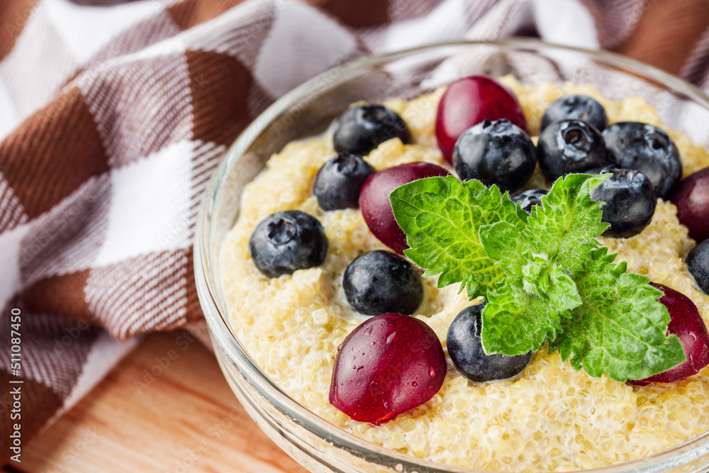 sweet porridge with quinoa and berries on a wooden rustic background sweet porridge with quinoa and berries on a wooden rustic background