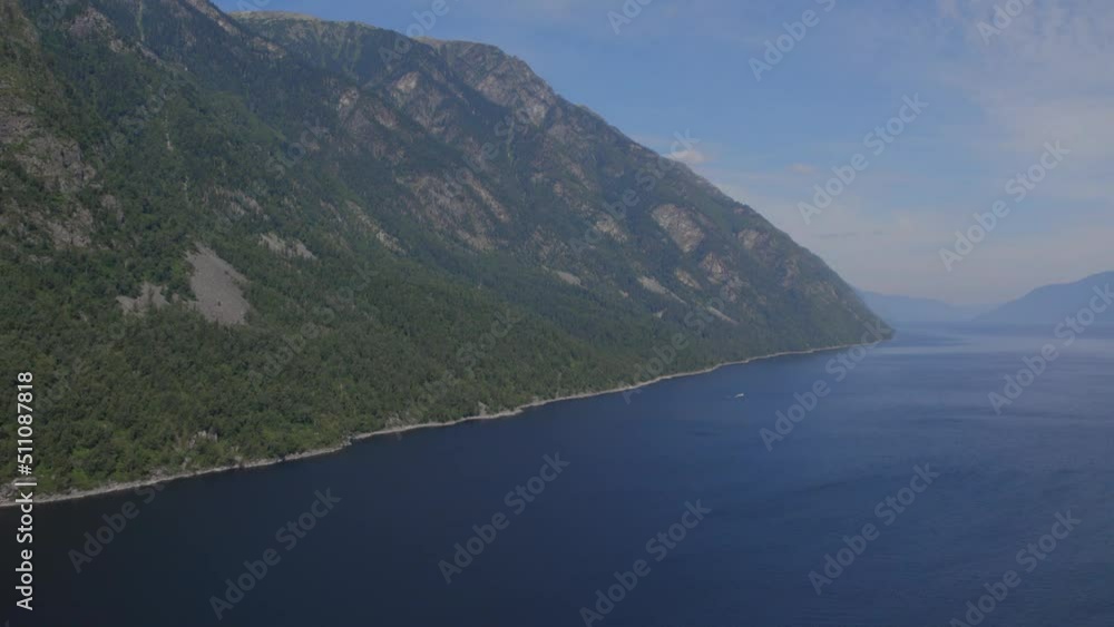 Lake Teletskoye between mountains with blue clear sky in Altai, Siberia, Russia. Beautiful summer nature landscape at during daytime. Aerial view from a drone Lake Teletskoye between mountains with blue clear sky in Altai, Siberia, Russia. Beautiful summer nature landscape at during daytime. Aerial view from a drone