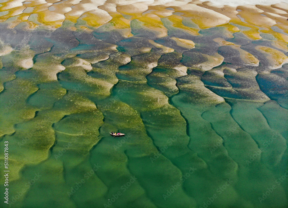 Huge sandbars arise in river Jamuna when the water level drops during the dry season. The striking pattern and textures look like desert when seen from above. Aerial sandbar view. Beauty of Nature. Huge sandbars arise in river Jamuna when the water level drops during the dry season. The striking pattern and textures look like desert when seen from above. Aerial sandbar view. Beauty of Nature.