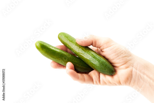 Hand of a woman holding a pair of green cucumbers