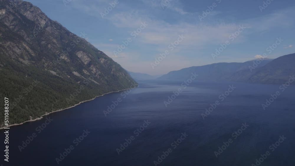 Lake Teletskoye between mountains with blue clear sky in Altai, Siberia, Russia. Beautiful summer nature landscape at during daytime. Aerial view from a drone Lake Teletskoye between mountains with blue clear sky in Altai, Siberia, Russia. Beautiful summer nature landscape at during daytime. Aerial view from a drone