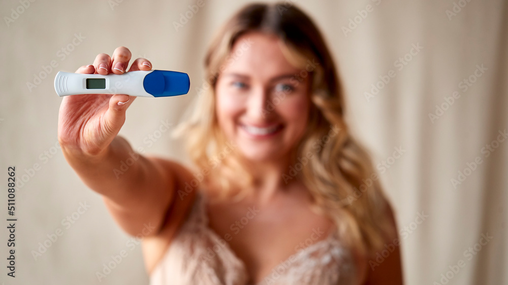 Studio Shot Of Body Positive Woman In Underwear Holding Positive Pregnancy Test Studio Shot Of Body Positive Woman In Underwear Holding Positive Pregnancy Test
