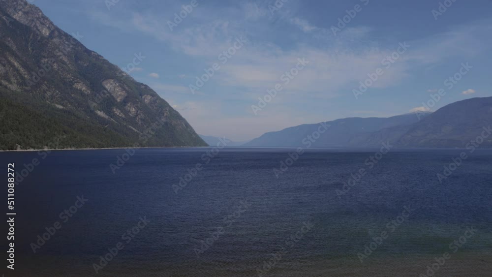 Lake Teletskoye between mountains with blue clear sky in Altai, Siberia, Russia. Beautiful summer nature landscape at during daytime. Aerial view from a drone Lake Teletskoye between mountains with blue clear sky in Altai, Siberia, Russia. Beautiful summer nature landscape at during daytime. Aerial view from a drone