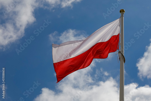 The flag of Poland flutters against the sky