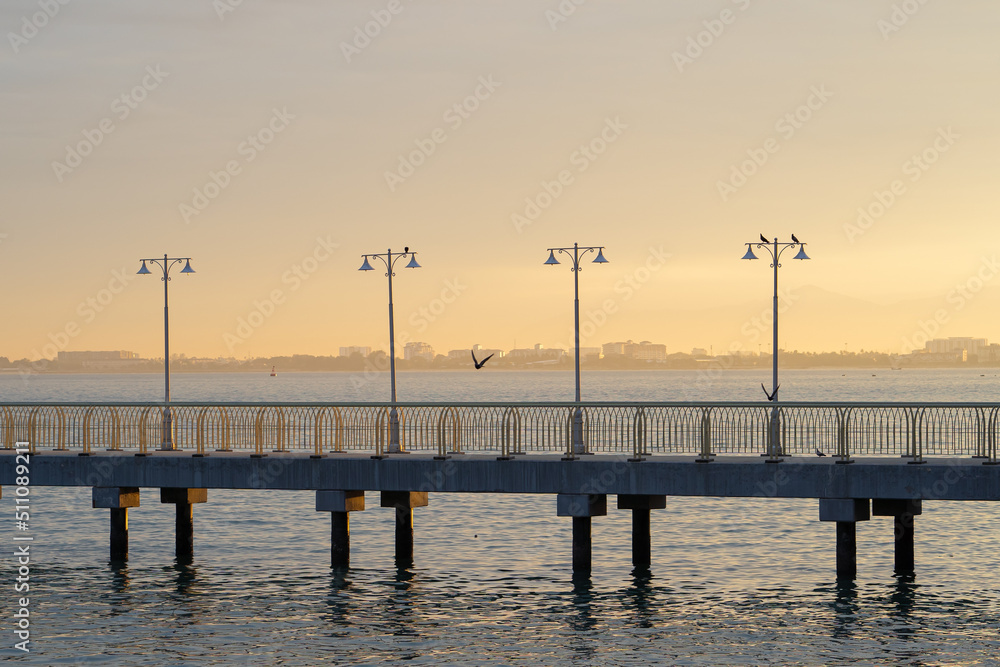 Close up of dodern concrete dock with lamp post during sunrise