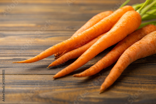 Fresh carrots on brown texture background. Ingredient for salad.Vegetarian organic vegetables.Healthy food.Copy space.Place for text