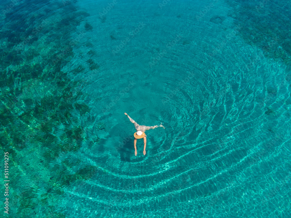 drone view of woman swimming in turquoise blue sea on island Molat, Croatia