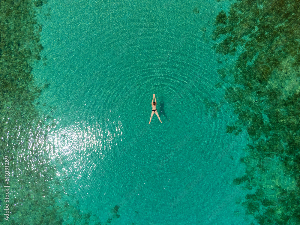 drone view of woman swimming in turquoise blue sea on island Molat, Croatia