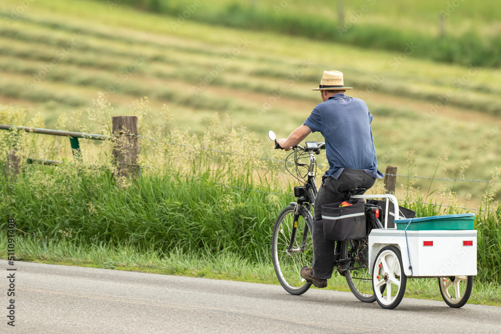 Amish man on a bicycle pulling a cart behind him | Holmes County, Ohio Amish man on a bicycle pulling a cart behind him | Holmes County, Ohio
