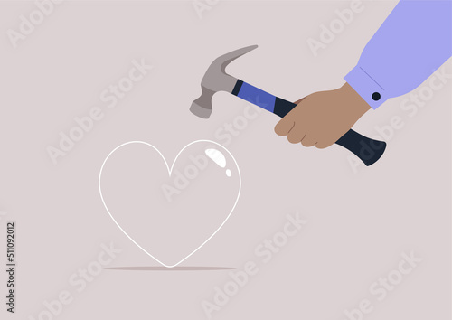 A hand breaking a glass heart with a hammer, unrequited love