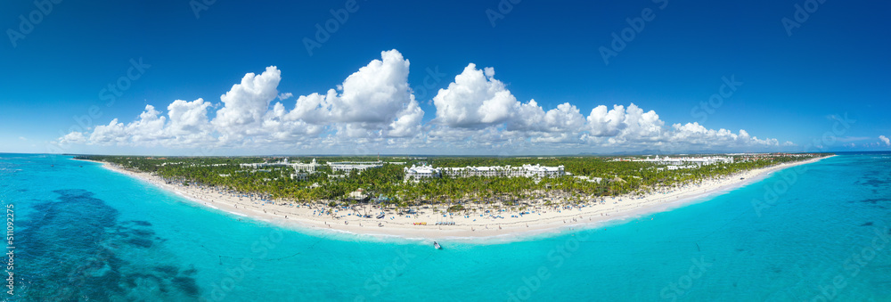 Obraz premium Bounty coastline with resorts, palm trees, caribbean sea and people having fun on beach. Dominican Republic. Aerial panorama view