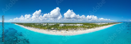 Bounty coastline with resorts, palm trees, caribbean sea and people having fun on beach. Dominican Republic. Aerial panorama view