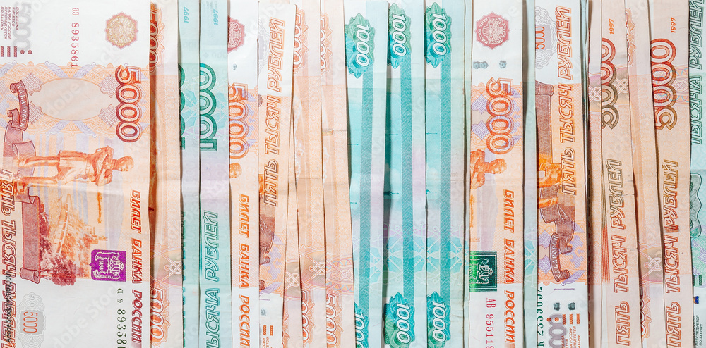 horizontal background of spread out paper money in denominations of one thousand and five thousand Russian rubles horizontal background of spread out paper money in denominations of one thousand and five thousand Russian rubles