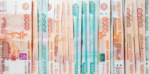horizontal background of spread out paper money in denominations of one thousand and five thousand Russian rubles