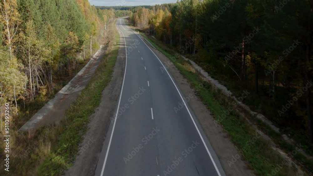 Asphalt road with traffic cars between forest in Ural, Russia. Beautiful autumn nature landscape at during daytime. Aerial view from a drone Asphalt road with traffic cars between forest in Ural, Russia. Beautiful autumn nature landscape at during daytime. Aerial view from a drone