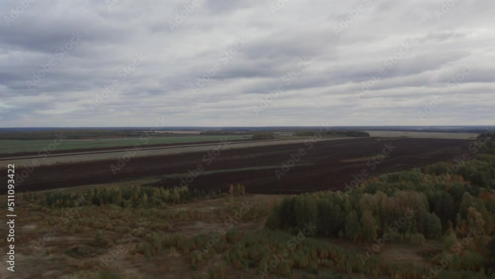 Green and brown rural fields with blue sky in autumn time in Ural, Russia. Beautiful autumn nature landscape at during daytime. Aerial view from a drone Green and brown rural fields with blue sky in autumn time in Ural, Russia. Beautiful autumn nature landscape at during daytime. Aerial view from a drone