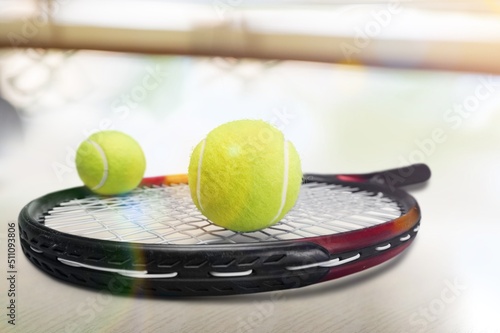 Black professional tennis racket and ball on background. Sport theme poster © BillionPhotos.com