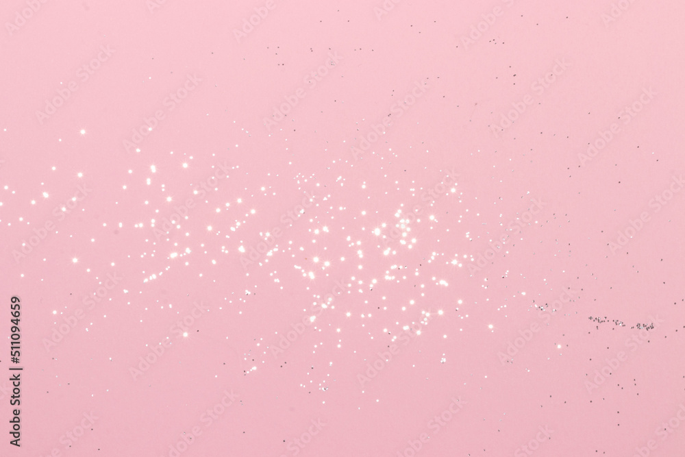 Sparkling silver glitter on pink background. Holiday blurred lights
