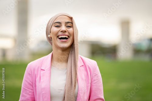 portrait of beautiful Muslim woman in hiyab happily sipping outdoors photo