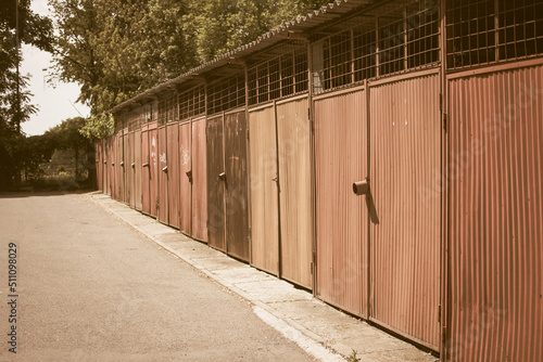 Old rusty garages in a row with rust and striped doors