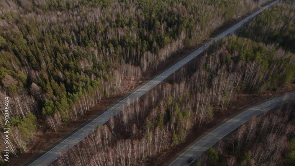 Curve of highway road between deep forest in Ural, Russia. Beautiful autumn nature landscape at during daytime. Aerial view from a drone Curve of highway road between deep forest in Ural, Russia. Beautiful autumn nature landscape at during daytime. Aerial view from a drone