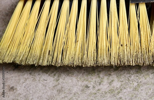 фотографія Close up of used yard broom with yellow bristles with copy space