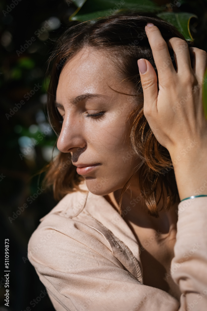 Cheerful smiling girl in a thicket of tropical plants. Large portrait Cheerful smiling girl in a thicket of tropical plants. Large portrait