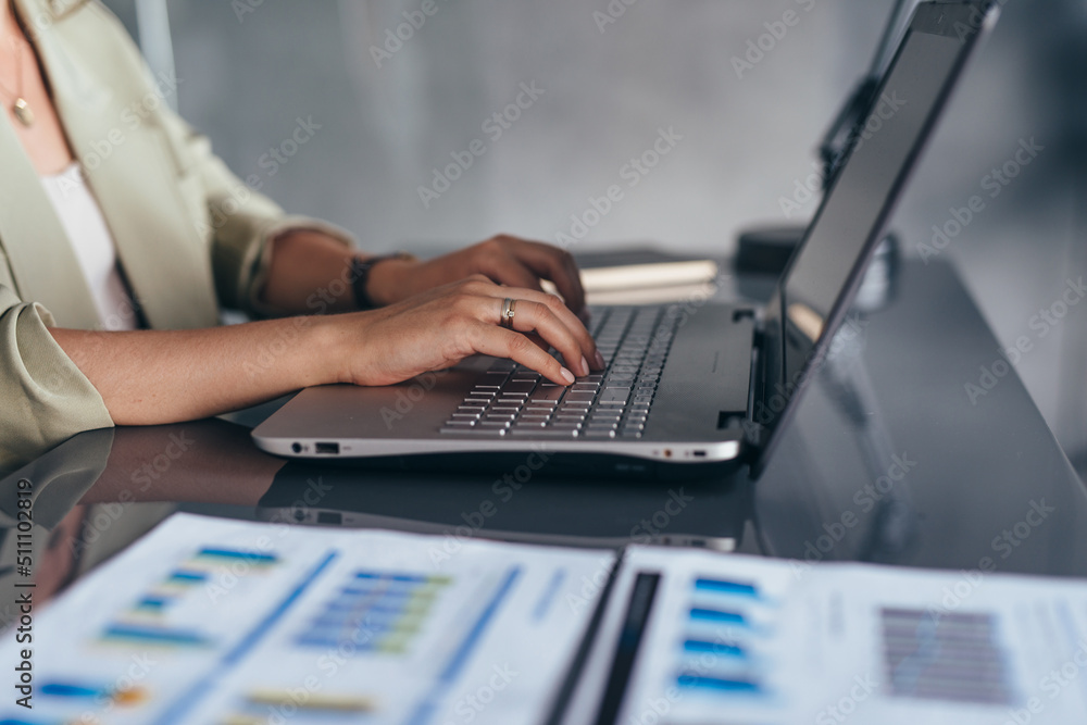 Woman working typing on laptop keyboard in office. Woman working typing on laptop keyboard in office.
