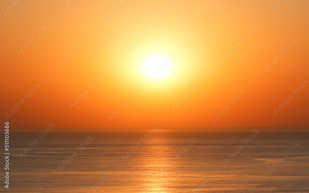 Bright sun on the horizon over the water during sunset