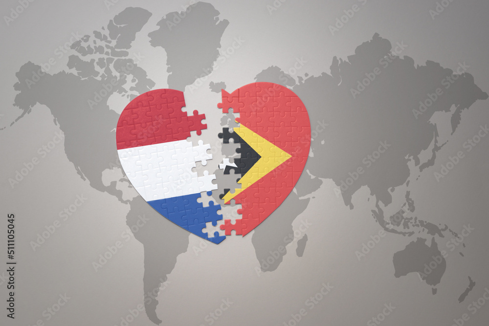 puzzle heart with the national flag of east timor and netherlands on a world map background.Concept. puzzle heart with the national flag of east timor and netherlands on a world map background.Concept.